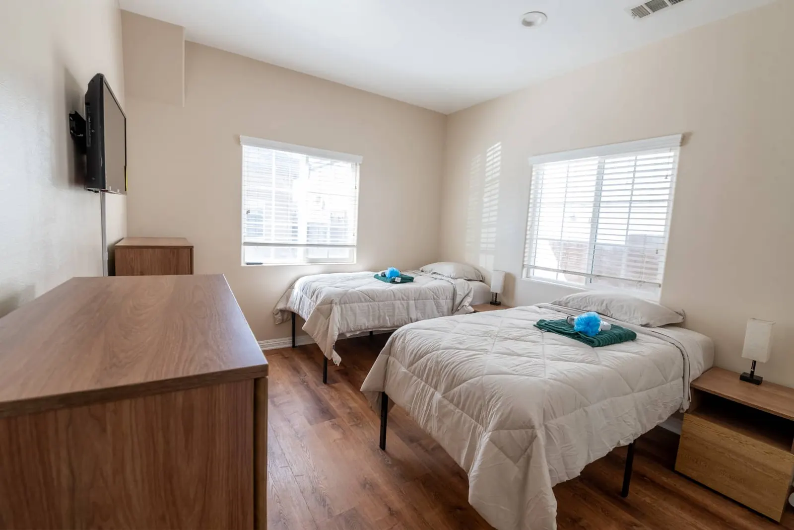 Shared bedroom with two beds and a dresser beside the window